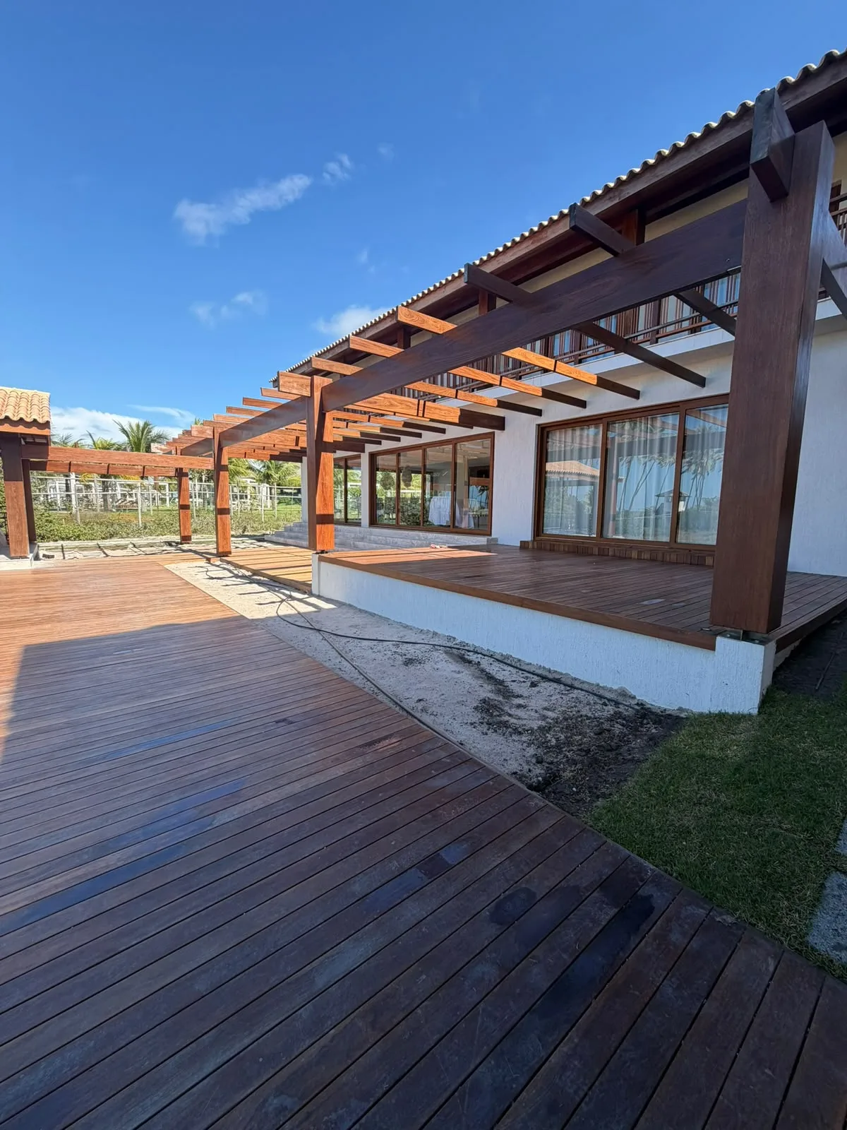 Pergolado de madeira sobre o deck e a varanda da Casa D’Ávila