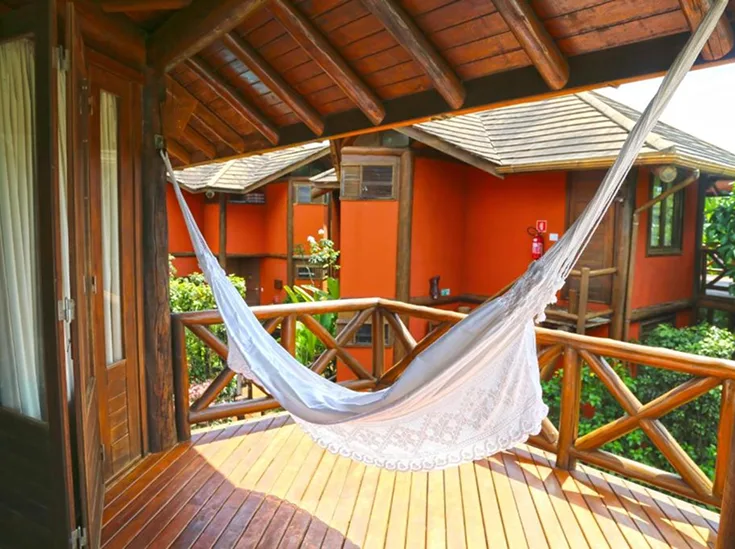 Fachada terracota e varanda com estrutura de madeira da Pousada Triboju em Fernando de Noronha